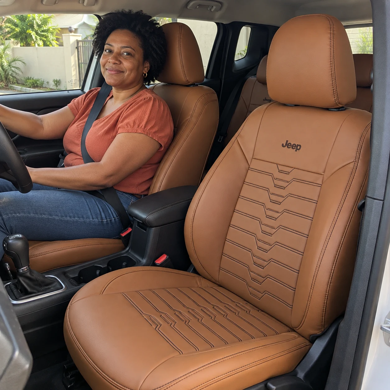 Renata de blusa terracota no Jeep Renegade com bancos caramelo, costura SPORT e logo Jeep bordada
